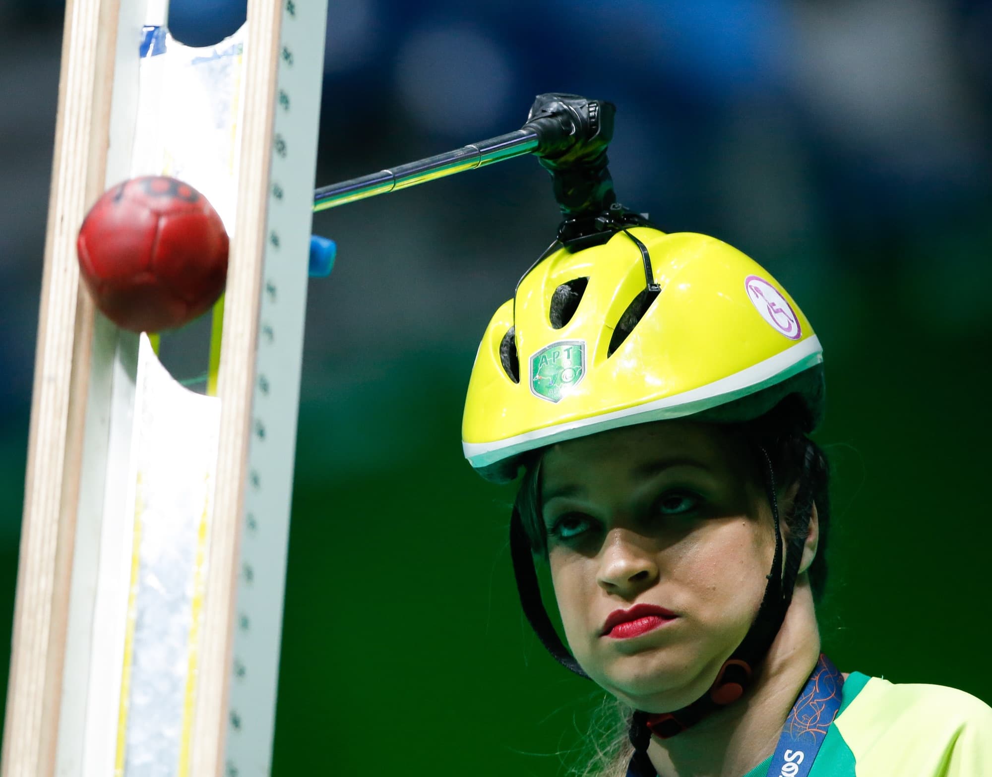 Atleta de bocha usa ponteira de cabeça e calha para lançar a bola em partida paralímpica