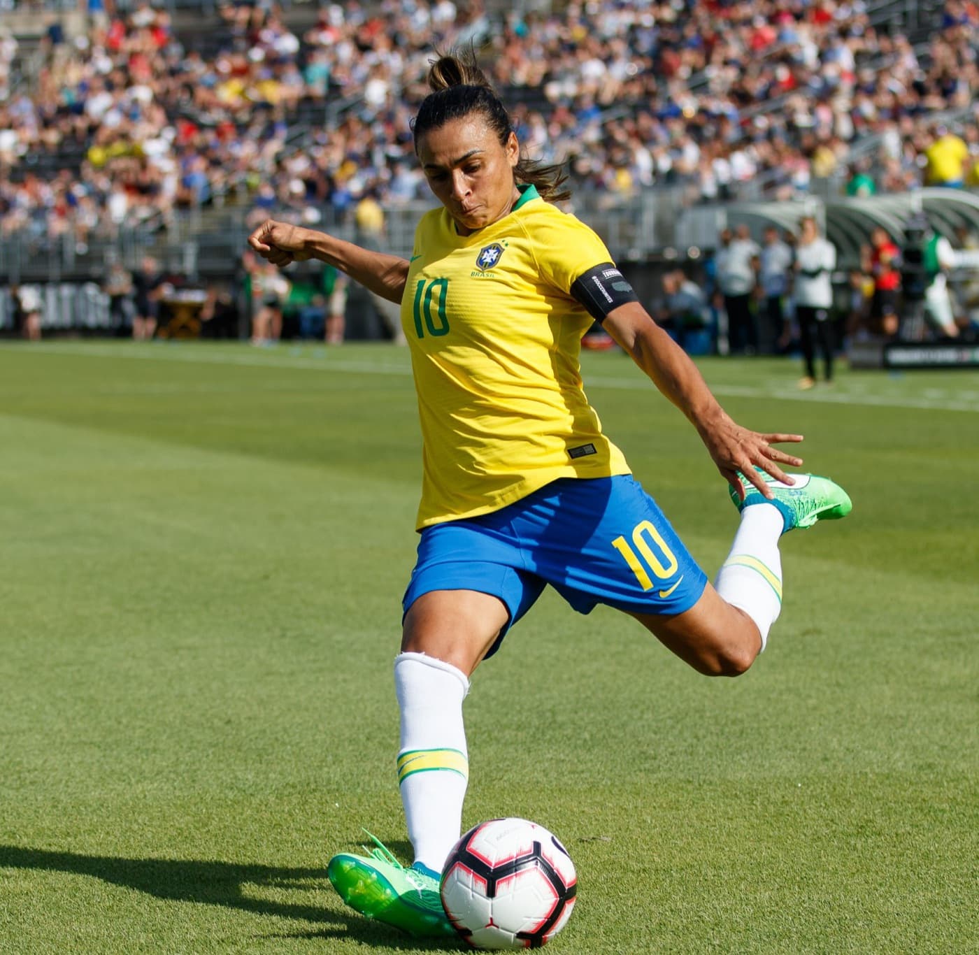 Jogadora da seleção brasileira arma o chute com a perna direita no gramado