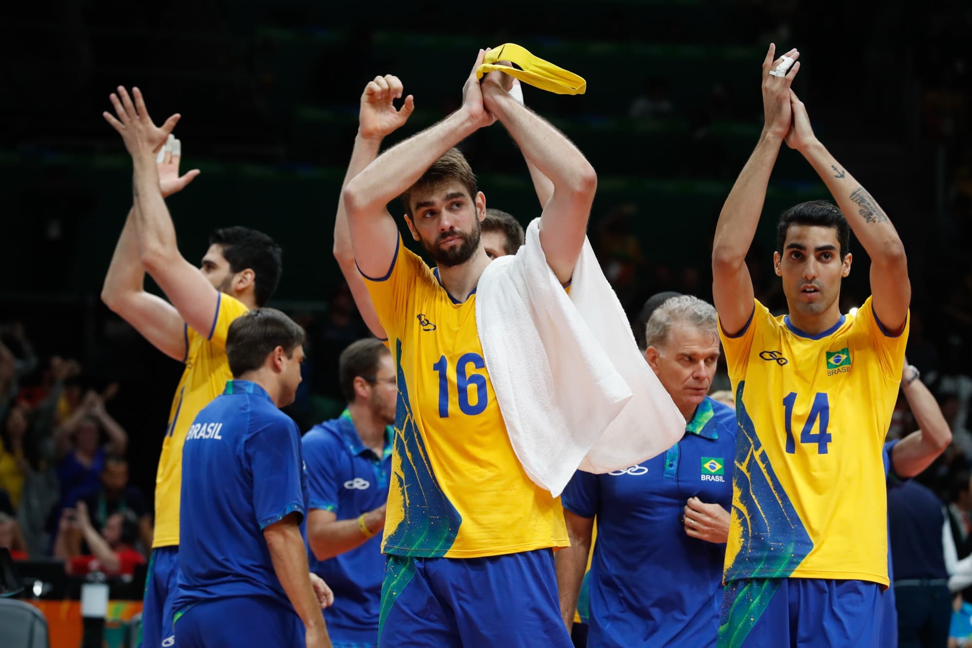 Jogadores da seleção brasileira de vôlei aplaudem a torcida com os braços para cima